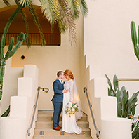 A bride and groom together on a staircase. 